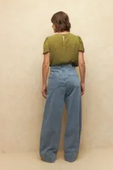 Top de manga corta color verde oliva, con cuello a la base y textura arrugada o plisada.