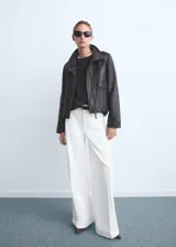 Jeans blancos de corte wide leg y tiro alto, con bolsillos de parche delanteros y trabillas para cinturón.