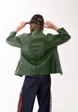 Campera de cuero color verde, con cierre frontal, cuello clásico y mangas largas. Presenta un diseño minimalista con un pequeño parche de cuero en el ruedo.