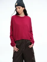 Sweater de corte relajado confeccionado en hilado suave con cashmere. Presenta cuello redondo, hombros caídos, mangas largas y una costura central vertical en el frente. El diseño posee un largo levemente más corto en la parte delantera.