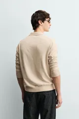 Sweater polo de punto de mezcla de algodón en color negro, con cuello solapa, abertura frontal y mangas largas con acabado en rib.