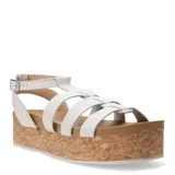 Sandalias tipo franciscanas con plataforma de corcho, tiras de cuero blanco y cierre con hebilla metálica lateral.