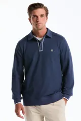Sweater de punto con textura tipo waffle, color azul, con cuello polo, cierre frontal parcial con botones y detalles de ribete en contraste. Presenta mangas largas con puños elásticos y logo bordado en el pecho.