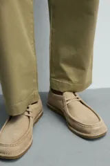 Zapato de cordones de hombre confeccionado en piel con acabado serraje en color beige, con detalle de bordón en el empeine, horma redonda y suela a contraste.
