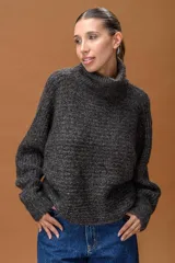 Sweater de cuello alto confeccionado en tejido de punto con sutiles destellos de lurex. Presenta mangas largas con puños ajustados y un calce holgado y cómodo.