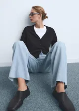 Pantalón de jean estilo wide leg con tiro alto, cinco bolsillos, trabillas para cinturón y bajo deshilachado.