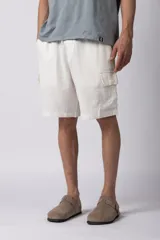 Bermuda cargo de lino y rayón color blanco, con bolsillos laterales tipo cargo, cintura elástica con cordón ajustable y calce relajado.