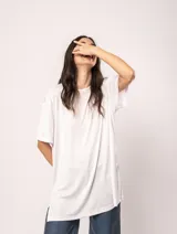 Remera blanca oversized de tela elastizada con tajos laterales y escote redondo.
