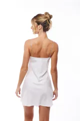 Vestido corto blanco de satén con escote en V y tirantes finos de strass.