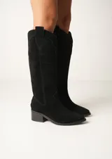 Botas texanas de cuero color beige con caña alta, taco de madera y cierre lateral.