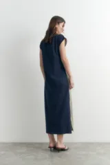 Vestido largo verde oliva con escote en V, sin mangas y detalle de botones a presión en los laterales.