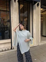 Poncho de hilo liviano en color verde claro, con diseño de cuello alto y caída fluida, ideal para media estación.