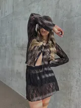 Falda corta de encaje negro con diseño semitransparente y cintura elástica.