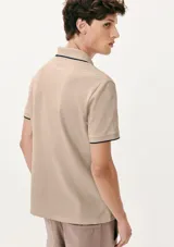 Chomba de manga corta color negro con cuello y tapeta interior en color gris claro. Presenta un pequeño bordado en el pecho y detalles de ribete en gris en el cuello y las mangas.