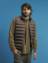 Chaleco acolchado de diseño capitoneado con cierre frontal al tono, cuello alto y ribetes en sisas y ruedo.