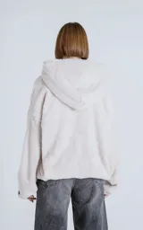 Hoodie oversize de piel sintética tipo corderito, color off-white, con capucha ajustable y bolsillo canguro frontal.