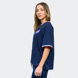 Remera de fútbol Umbro del Club Nacional de Football para mujer. Diseño azul con detalles tricolor en cuello y mangas. Incluye logo de Umbro y escudo del club en el frente.