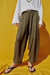 Pantalón de lino marrón oscuro, de corte barrel con pernera holgada que se estrecha hacia el tobillo, cintura elástica y bolsillos delanteros.