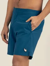 Short de baño azul petróleo de tejido Seersucker con elástano, con botón oculto a presión, elástico en la cintura trasera, dos bolsillos laterales y trasero con cierre, y suspensor de malla fina hipoalergénico.