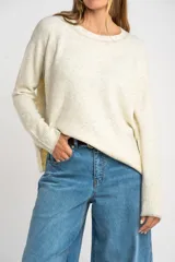 Sweater color crema de tejido de punto con cuello redondo y mangas largas.