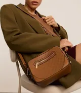 Bandolera negra pequeña de material sintético con textura geométrica. Tiene correa ancha regulable, cierre de cremallera, separadores internos y bolsillo externo con cremallera.