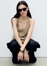 Musculosa color verde oliva con bajo asimétrico, cuello redondo y tirantes anchos.