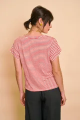 Remera de corte holgado, con diseño a rayas horizontales en color crudo y azul marino, cuello redondo y mangas cortas con vuelta.