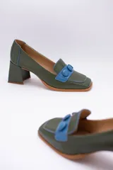 Zapato de cuero verde con aplique de cuero azul y botones forrados.