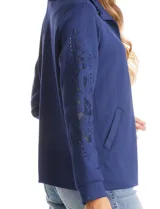 Campera liviana de modal con cuello solapa y cierre frontal mediante broches metálicos. Presenta mangas largas con detalles de bordado floral calado y puños en rib, además de bolsillos laterales funcionales.