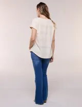 Blusa celeste de tejido calado tipo pointelle, con escote redondo, mangas cortas con dobladillo y presilla con botón, y ruedo curvo.