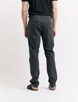 Pantalón de vestir marrón, de corte recto, con bolsillos laterales y traseros. Se ajusta a la cintura con cinturón de cuero marrón.