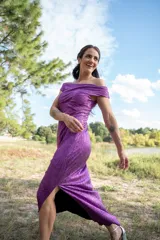 Vestido midi color violeta metalizado, con escote bote drapeado, sin mangas y diseño fluido con pliegues laterales.