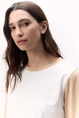 Remera de algodón de mangas largas, con cuerpo blanco, mangas color beige y laterales color gris.