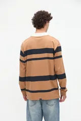 Remera polo de manga larga con diseño de rayas horizontales rojas sobre fondo blanco, cuello camisero tostado con media cartera de botones y puños ajustados.