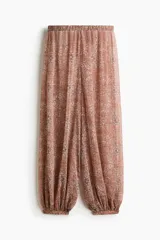 Pantalón globo rosado con estampado paisley, cintura elástica y bajos ajustados con elástico.