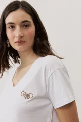 Remera de manga corta y cuello en V color blanco, con bordado en el pecho.