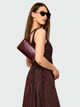 Cartera tipo shoulder bag Marc Jacobs modelo The Puffy J Marc, de cuero color bordó con detalles metálicos dorados.