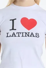 Remera blanca de algodón con mangas cortas y cuello redondo. Estampado frontal con la frase "I ❤️ Latinas" en color negro y rojo.