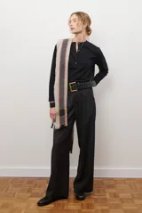 Remera de manga larga en color rosado, con cuello redondo y cierre frontal parcial con botones. Presenta un diseño de corte recto y estilo minimalista.