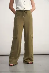 Pantalón cargo color verde oliva, de corte ancho, con bolsillos laterales con solapa y cintura con cordón ajustable.
