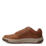 Zapatos urbanos Caterpillar modelo Apa Cush, color marrón, confeccionados en cuero con detalles en gamuza en el talón. Presentan cierre con cordones, suela de goma en tono beige y logo de la marca en el lateral.