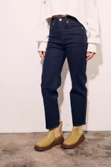 Pantalón de jean de tiro medio, color azul oscuro, corte recto y cinco bolsillos.