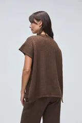 Chaleco tejido de punto con silueta cuadrada y escote a la base, de diseño minimalista y estructura holgada.