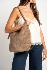 Blusa satinada marrón con detalles de encaje en el escote en V y en el ruedo. Presenta tirantes finos regulables.