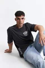 Remera negra de algodón con corte oversize, cuello redondo y manga corta. Estampado frontal con la frase "Explore Discover Grow" y el logo de la marca Mistral.