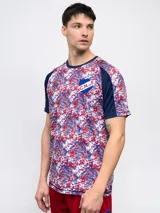 Remera de fútbol Umbro del Club Nacional de Football, modelo Pro Training Active. Diseño con estampado abstracto en blanco, rojo y azul, con mangas raglán azul marino y escudo del club en el pecho.
