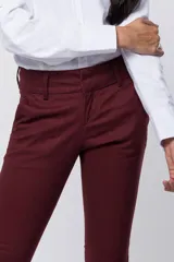 Pantalón skinny de gabardina en color bordó, de corte ajustado, tiro medio y con trabillas para cinto en la cintura.