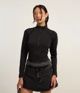 Blusa negra de microfibra con cuello alto y cierre frontal con cremallera, de manga larga y corte ajustado.
