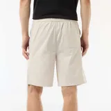 Bermuda chino color gris claro, de corte recto, con cintura elástica ajustable mediante cordón y bolsillos laterales.