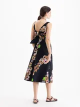 Vestido maxi negro con estampado floral, silueta en A, escote cuadrado con bandeau superpuesto y lazo en la espalda.